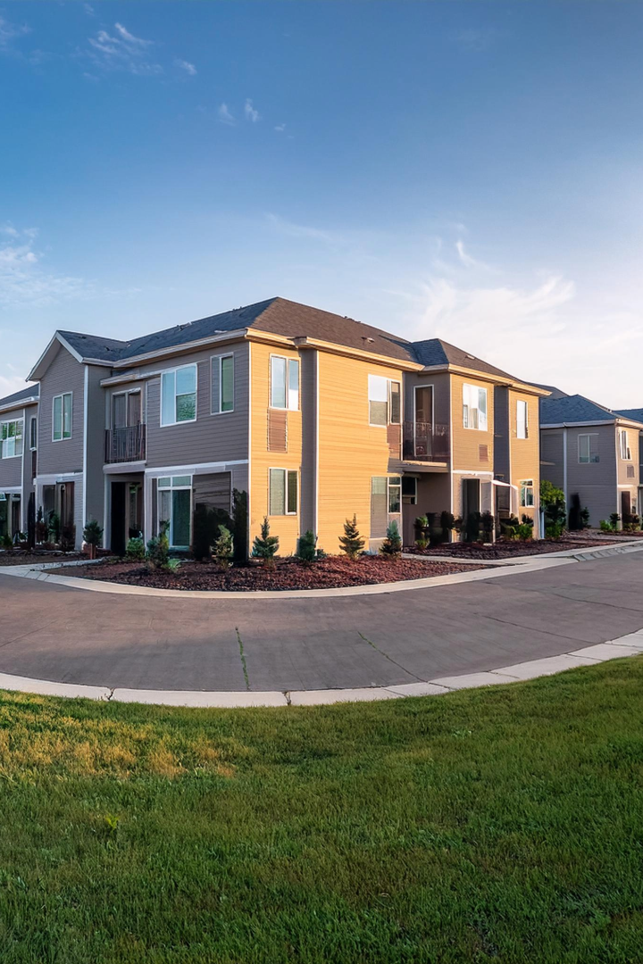 the exterior of a residential complex with a green lawn at The Bella Vista Towers